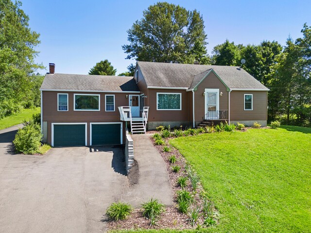 63 N Shore Dr, Owls Head, ME 04854 - view of front of property with a chimney, asphalt driveway, an attached garage, a front lawn, and roof with shingles