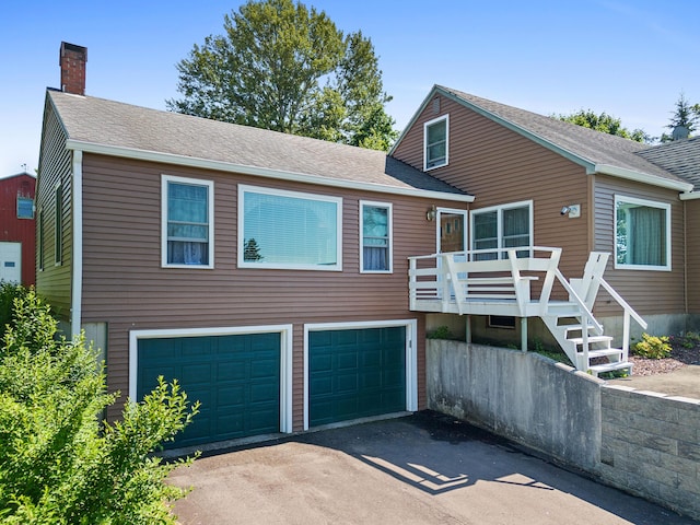 63 N Shore Dr, Owls Head, ME 04854 - view of front of house featuring a garage, driveway, a chimney, a deck, and a shingled roof
