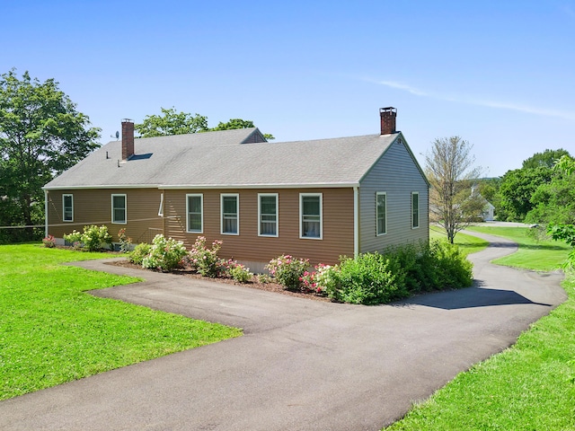 63 N Shore Dr, Owls Head, ME 04854 - view of front of property with a chimney, a front yard, driveway, and a shingled roof