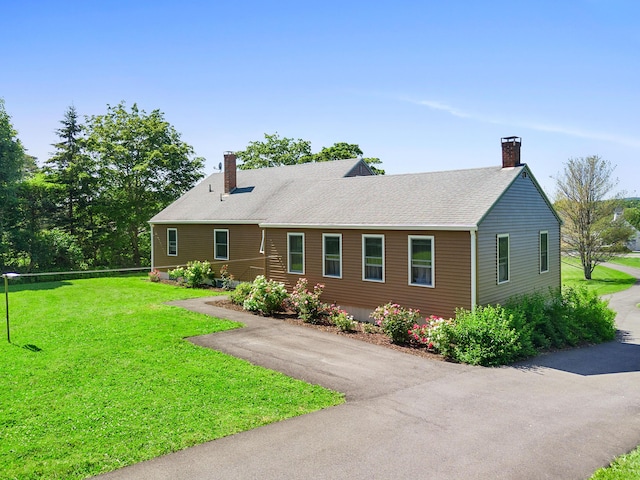 63 N Shore Dr, Owls Head, ME 04854 - view of front of property featuring a chimney, a front lawn, and roof with shingles