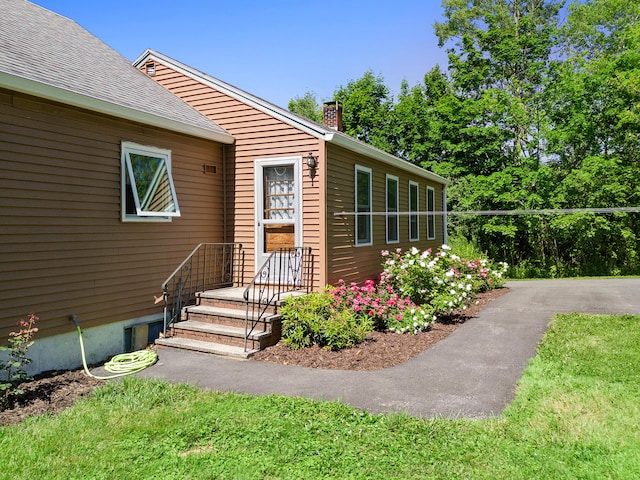 63 N Shore Dr, Owls Head, ME 04854 - doorway to property with a chimney and roof with shingles