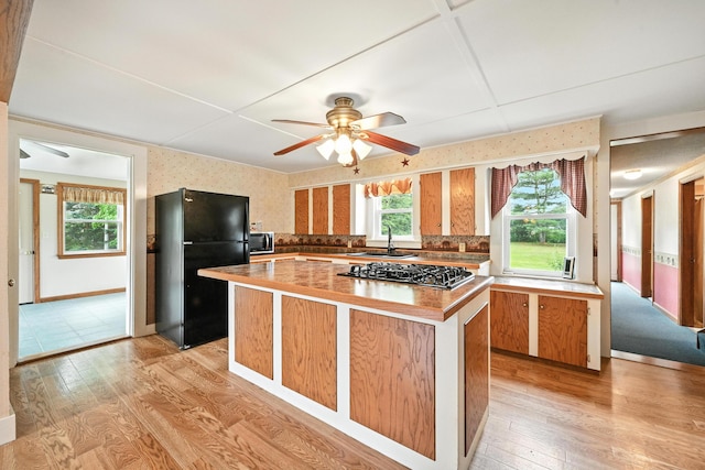 23 W St, Benton, ME 04901 - kitchen with freestanding refrigerator, a ceiling fan, wallpapered walls, light wood finished floors, and a kitchen island