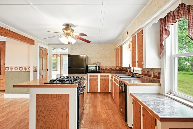 23 W St, Benton, ME 04901 - kitchen with black appliances, light wood-style flooring, wallpapered walls, a kitchen island, and a ceiling fan