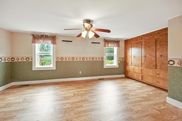 23 W St, Benton, ME 04901 - unfurnished bedroom featuring multiple windows, light wood-style flooring, and ceiling fan