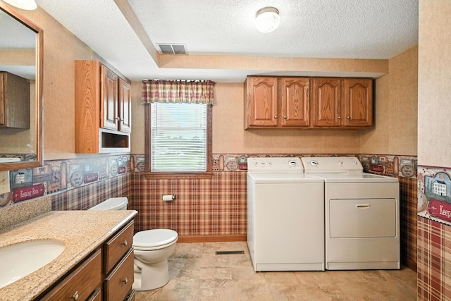 23 W St, Benton, ME 04901 - bathroom with washing machine and dryer, wallpapered walls, vanity, a wainscoted wall, and a textured ceiling