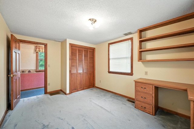 23 W St, Benton, ME 04901 - unfurnished bedroom featuring light colored carpet, a closet, a textured ceiling, and a desk