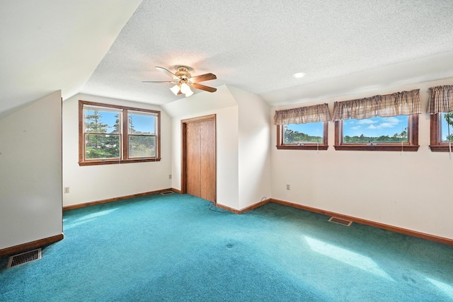 23 W St, Benton, ME 04901 - additional living space with ceiling fan, carpet, vaulted ceiling, healthy amount of natural light, and a textured ceiling
