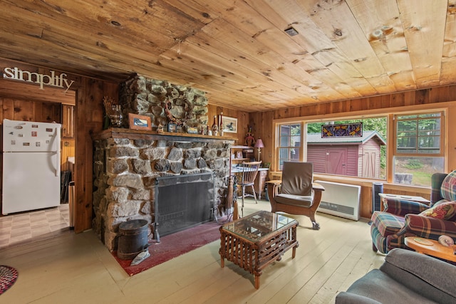 199 Peace Pipe Dr, Litchfield, ME 04350 - living area with wood ceiling, wood walls, hardwood / wood-style flooring, and a stone fireplace