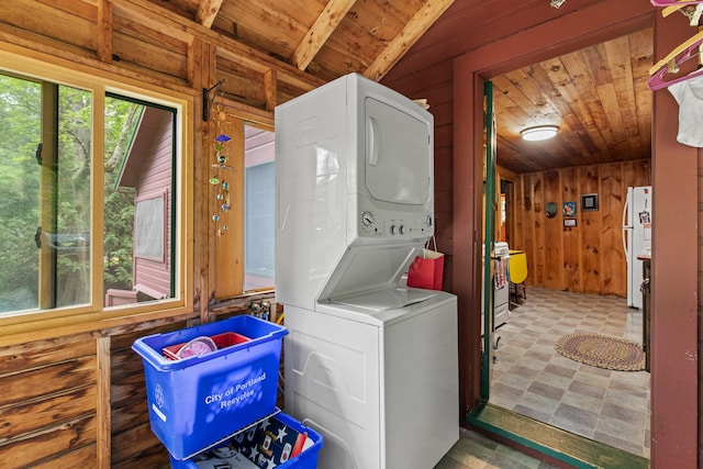 199 Peace Pipe Dr, Litchfield, ME 04350 - washroom featuring stacked washing machine and dryer, wooden ceiling, wood walls, and tile patterned floors