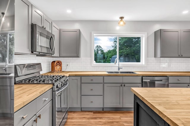 985 Main Rd, Eddington, ME 04428 - kitchen featuring butcher block countertops, appliances with stainless steel finishes, gray cabinets, backsplash, and recessed lighting