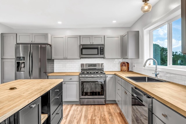 985 Main Rd, Eddington, ME 04428 - kitchen with butcher block counters, stainless steel appliances, gray cabinets, decorative backsplash, and recessed lighting