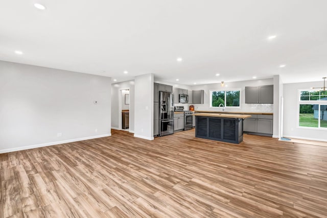 985 Main Rd, Eddington, ME 04428 - kitchen featuring gray cabinets, stainless steel appliances, open floor plan, light wood-style flooring, and recessed lighting