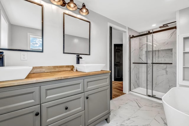 985 Main Rd, Eddington, ME 04428 - full bathroom featuring marble look tiles, a marble finish shower, double vanity, and a soaking tub