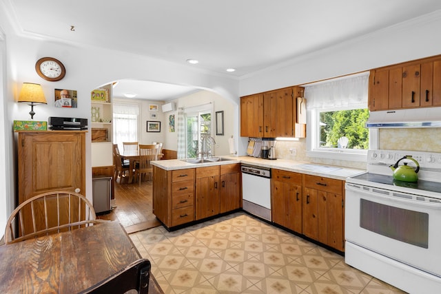 50-52 Mechanic St, Rockland, ME 04841 - kitchen featuring white appliances, under cabinet range hood, arched walkways, a peninsula, and healthy amount of natural light
