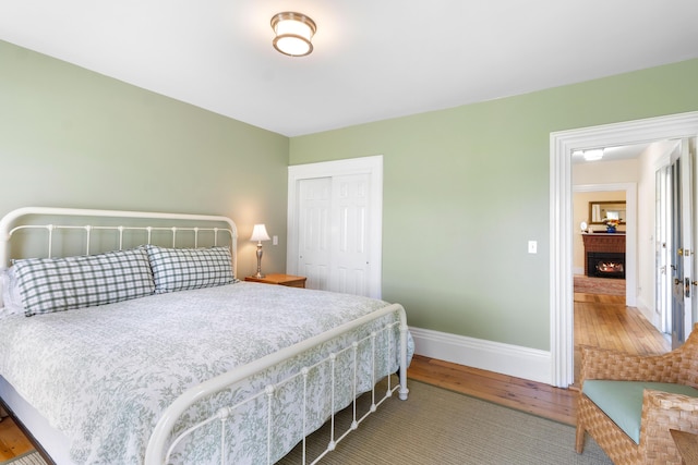 50-52 Mechanic St, Rockland, ME 04841 - bedroom with wood-type flooring, a warm lit fireplace, and a closet