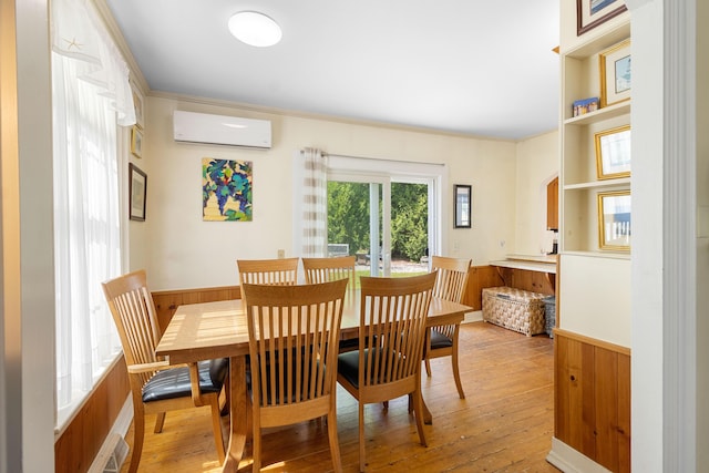 50-52 Mechanic St, Rockland, ME 04841 - dining area featuring light wood-type flooring, an AC wall unit, wainscoting, and crown molding