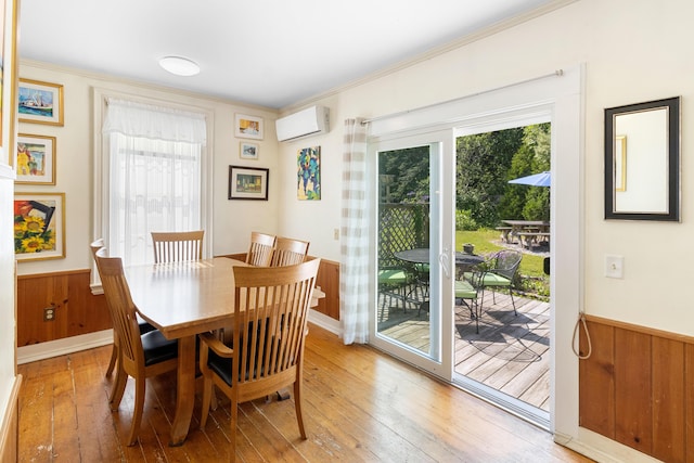 50-52 Mechanic St, Rockland, ME 04841 - dining space featuring healthy amount of natural light, wood-type flooring, a wall mounted air conditioner, a wainscoted wall, and crown molding