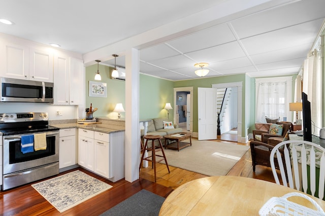 50-52 Mechanic St, Rockland, ME 04841 - kitchen with appliances with stainless steel finishes, open floor plan, white cabinets, dark wood-type flooring, and recessed lighting