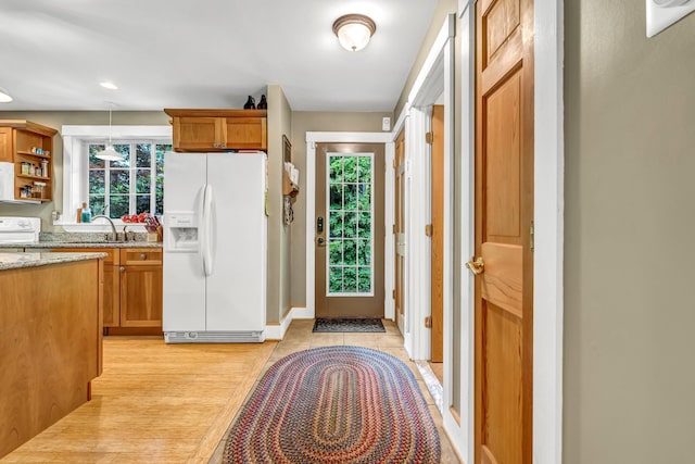 2 Falling Pines Ln, Readfield, ME 04355 - kitchen with white fridge with ice dispenser, light stone countertops, plenty of natural light, and decorative light fixtures