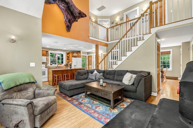 2 Falling Pines Ln, Readfield, ME 04355 - living area with light wood finished floors, a towering ceiling, and stairway