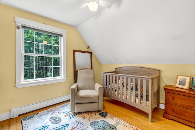 2 Falling Pines Ln, Readfield, ME 04355 - bedroom featuring baseboard heating, lofted ceiling, wood finished floors, a ceiling fan, and a nursery area
