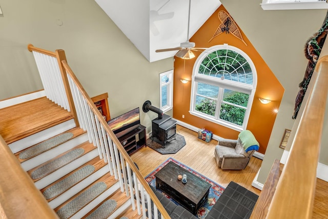 2 Falling Pines Ln, Readfield, ME 04355 - living area with a wood stove, wood finished floors, high vaulted ceiling, a ceiling fan, and stairway