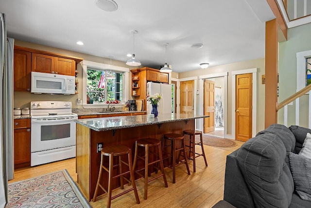 2 Falling Pines Ln, Readfield, ME 04355 - kitchen with white appliances, a kitchen breakfast bar, open floor plan, dark stone counters, and light wood-style floors