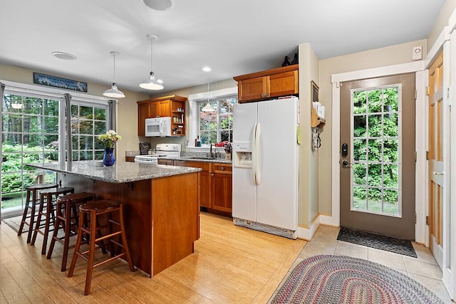 2 Falling Pines Ln, Readfield, ME 04355 - kitchen with white appliances, brown cabinets, a kitchen island, a breakfast bar, and recessed lighting