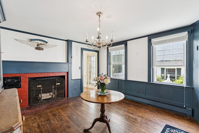 26 Grove St, Bath, ME 04530 - living room with baseboard heating, a chandelier, a brick fireplace, and hardwood / wood-style flooring