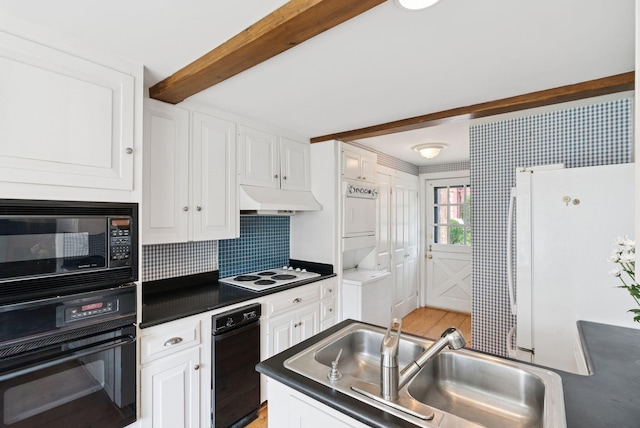 26 Grove St, Bath, ME 04530 - kitchen with black appliances, estacked washer and dryer, under cabinet range hood, dark countertops, and white cabinetry