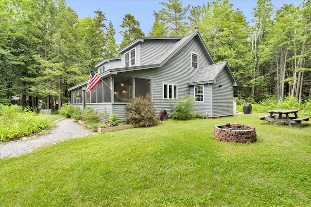 134 Powers Drive Ln, Orland, ME 04472 - view of property exterior with an outdoor fire pit, a sunroom, and a yard
