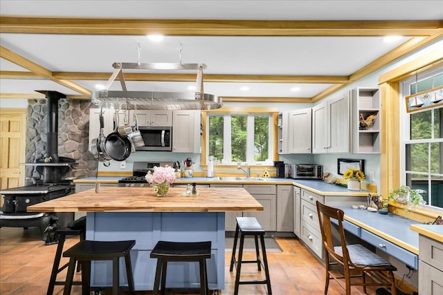 134 Powers Drive Ln, Orland, ME 04472 - kitchen with stainless steel appliances, wooden counters, a breakfast bar area, plenty of natural light, and beamed ceiling