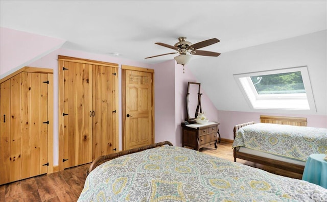 134 Powers Drive Ln, Orland, ME 04472 - bedroom featuring a skylight, wood finished floors, vaulted ceiling, two closets, and ceiling fan