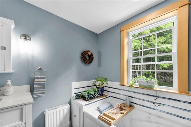 134 Powers Drive Ln, Orland, ME 04472 - bathroom featuring a tub to relax in, backsplash, and radiator