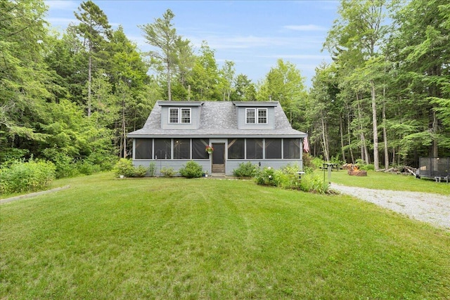 134 Powers Drive Ln, Orland, ME 04472 - view of front facade featuring a sunroom, a front lawn, a wooded view, and gravel driveway