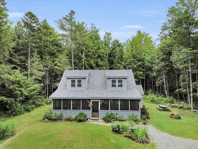 134 Powers Drive Ln, Orland, ME 04472 - view of front of property featuring a sunroom, a fire pit, and a forest view
