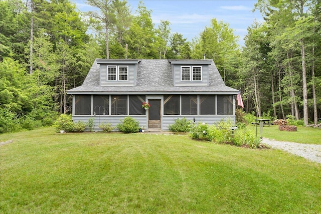 134 Powers Drive Ln, Orland, ME 04472 - view of front of home featuring a sunroom, a front yard, a shingled roof, and a forest view