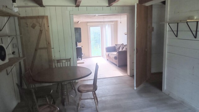 2198 Eight Rod Rd, Sidney, ME 04330 - dining room featuring wood walls, wood finished floors, and beam ceiling