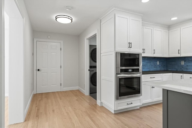 35 Rice Rd, Boothbay, ME 04544 - kitchen with oven, estacked washer and dryer, light wood-style flooring, built in microwave, and decorative backsplash