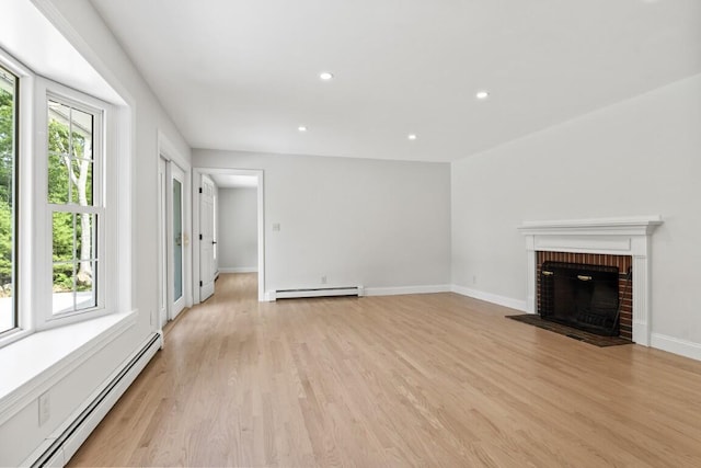 35 Rice Rd, Boothbay, ME 04544 - unfurnished living room featuring a baseboard radiator, baseboard heating, light wood finished floors, a brick fireplace, and recessed lighting