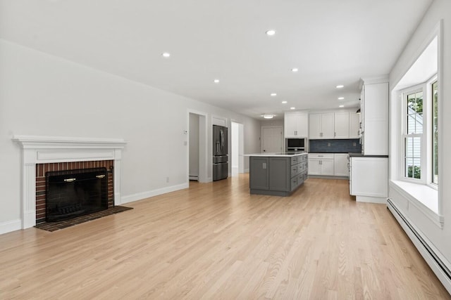 35 Rice Rd, Boothbay, ME 04544 - unfurnished living room with baseboard heating, recessed lighting, light wood-style flooring, and a fireplace