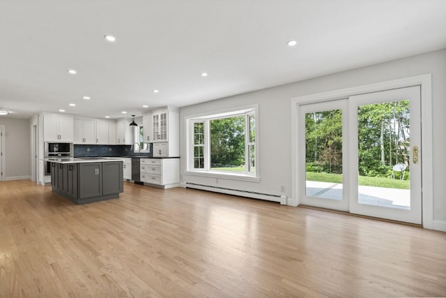 35 Rice Rd, Boothbay, ME 04544 - kitchen with appliances with stainless steel finishes, baseboard heating, white cabinetry, a center island, and tasteful backsplash