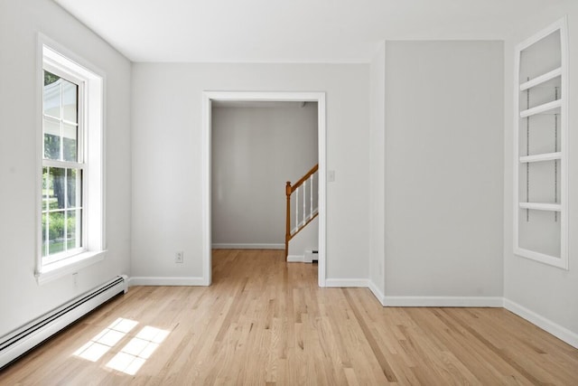 35 Rice Rd, Boothbay, ME 04544 - empty room featuring a baseboard radiator, light wood-style flooring, built in shelves, and stairs