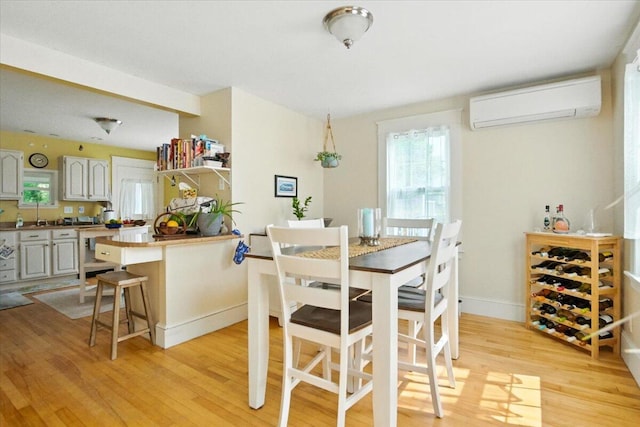 278 S Main St, Auburn, ME 04210 - dining area with a wall mounted air conditioner, light wood finished floors, and plenty of natural light