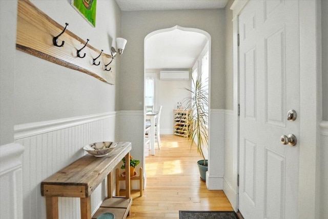 278 S Main St, Auburn, ME 04210 - hallway featuring light wood-style flooring, a wainscoted wall, and an AC wall unit