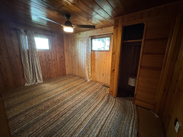 157 Cyr Rd, Cross Lake Twp, ME 04779 - unfurnished bedroom featuring wooden walls, carpet floors, a closet, wood ceiling, and ceiling fan