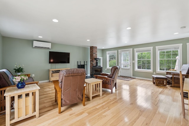 3729 Union St, Levant, ME 04456 - living room with a wood stove, light wood-style floors, recessed lighting, and a wall mounted AC