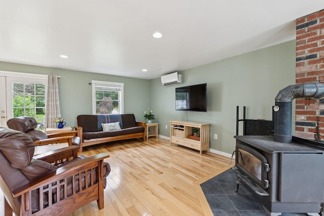 3729 Union St, Levant, ME 04456 - living room with a wood stove, wood finished floors, recessed lighting, and a wall unit AC