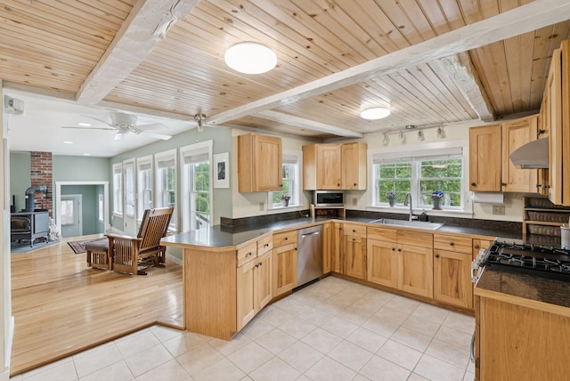3729 Union St, Levant, ME 04456 - kitchen with dark countertops, a peninsula, a wood ceiling with exposed beams, light tile patterned floors, and a wood stove