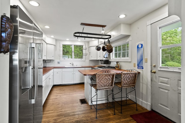 28 Will Alley Rd, South Bristol, ME 04568 - kitchen with stainless steel refrigerator with ice dispenser, a breakfast bar area, white cabinetry, wooden counters, and dark wood-style floors